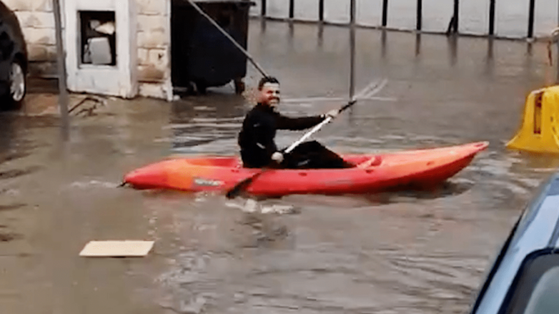 Kayakers make a splash in flooded city street (Video)