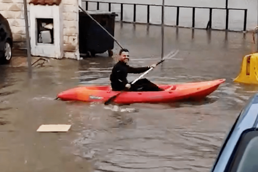 Kayakers make a splash in flooded city street (Video)